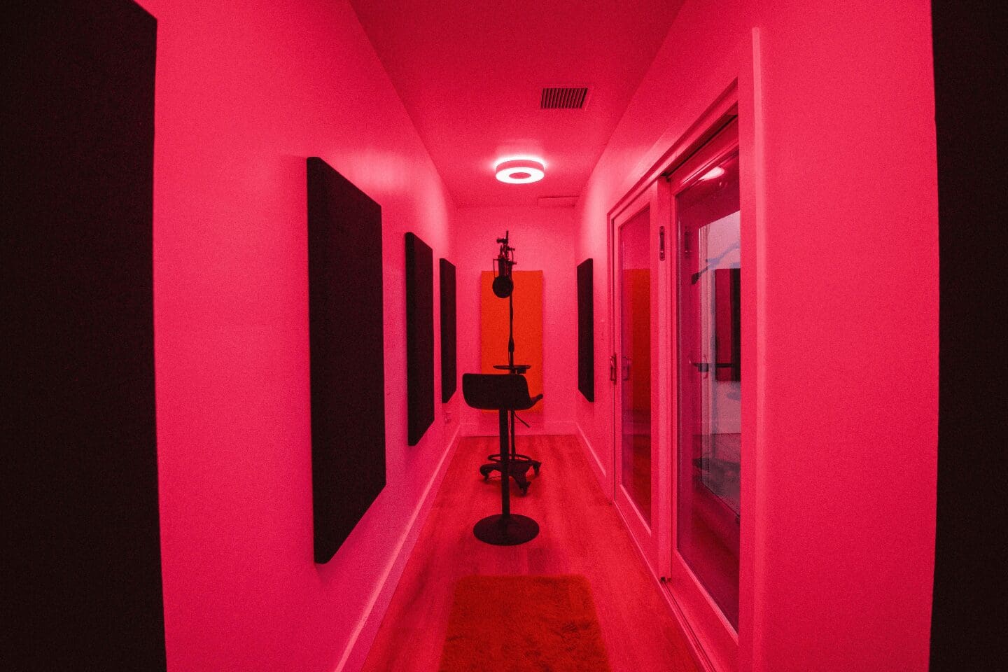 A red hallway with a microphone and some mirrors