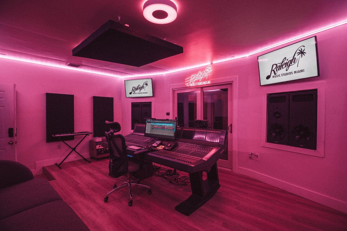 A room with pink lighting and a desk