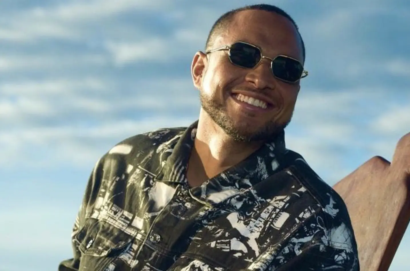 A man wearing sunglasses and smiling for the camera.