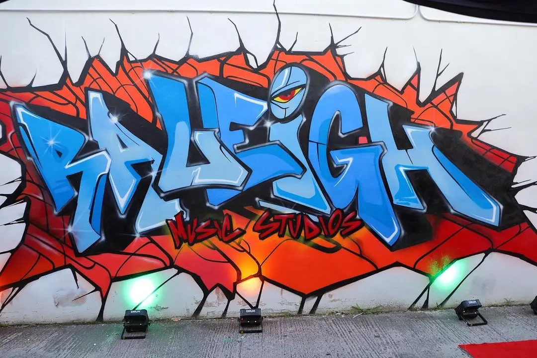 A wall with graffiti on it and the word " raleigh ".