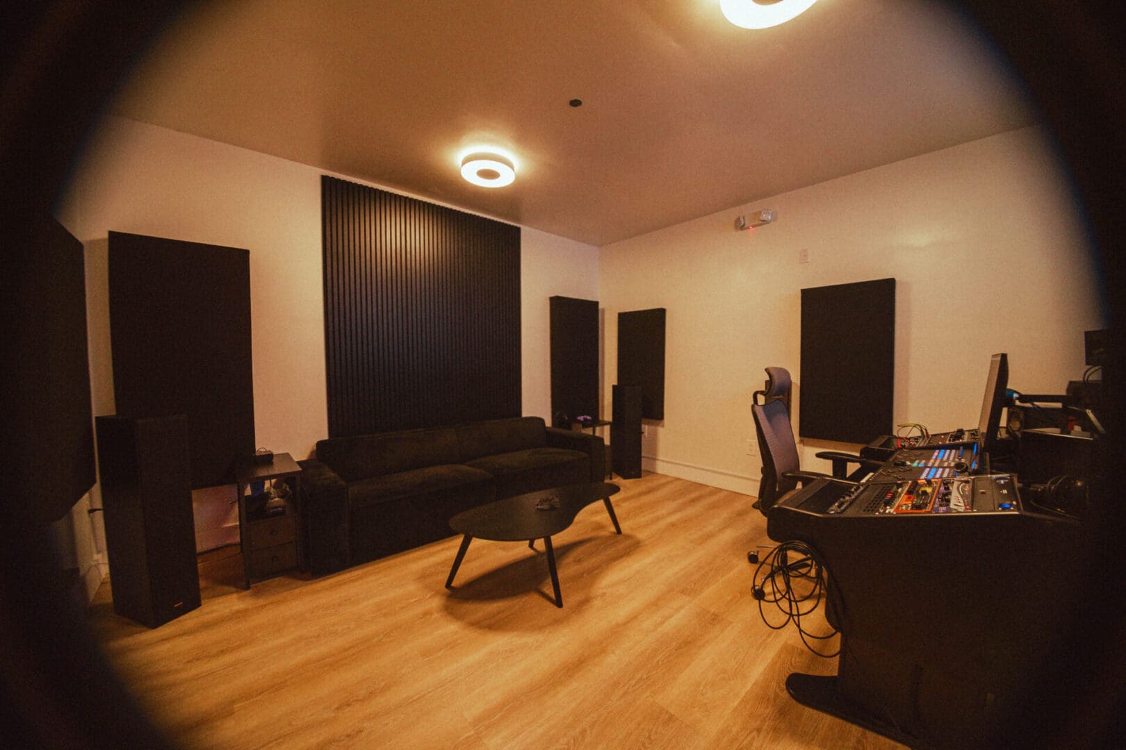 A room with two large speakers and a couch.