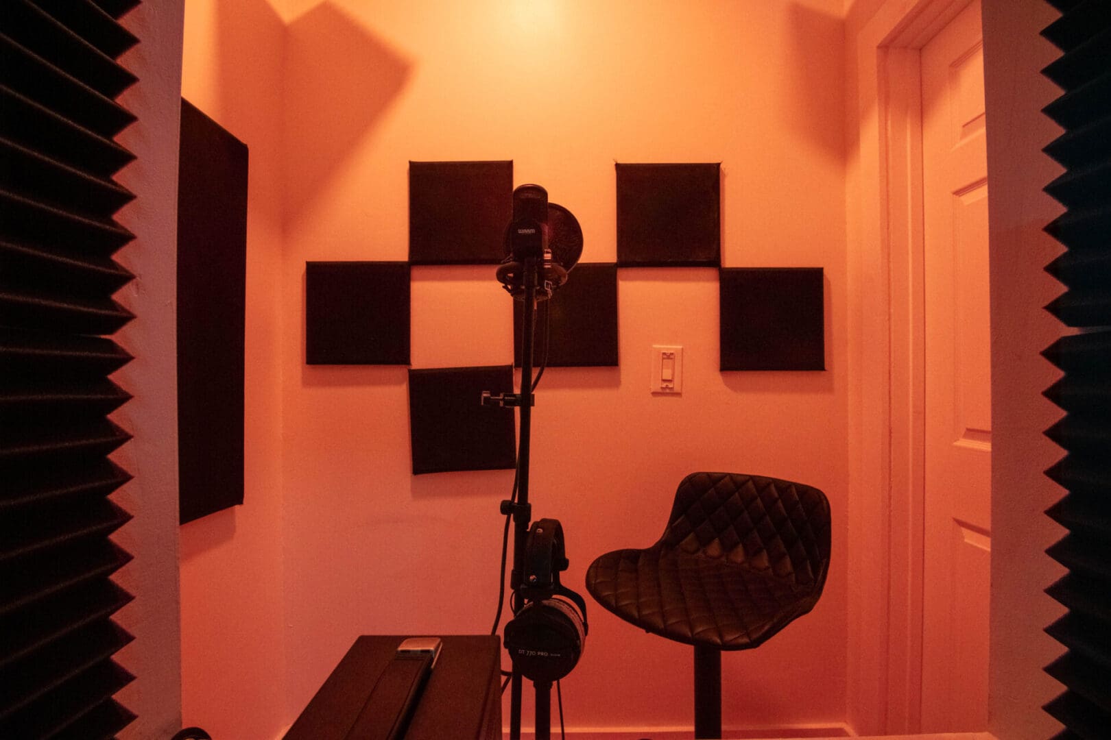 A room with a microphone and speakers on the wall