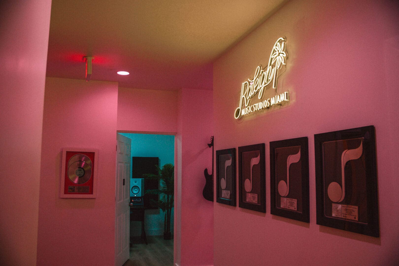 A pink room with several pictures on the wall.