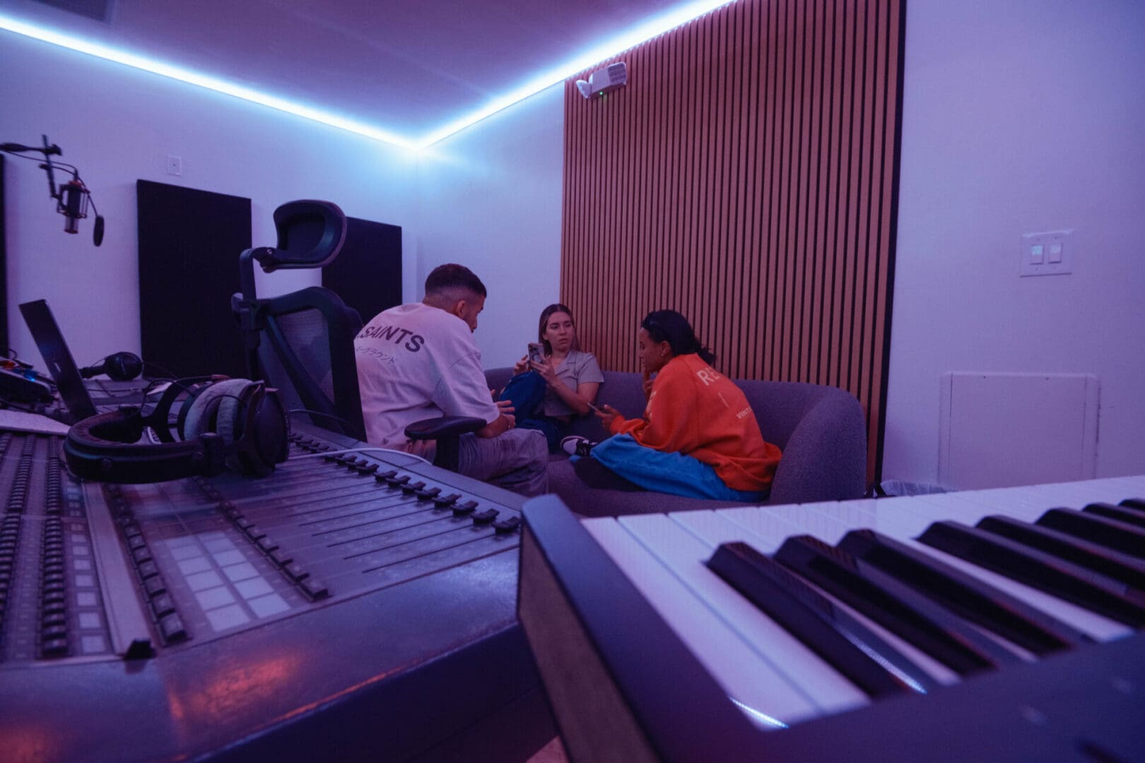 A group of people sitting around in front of a keyboard.