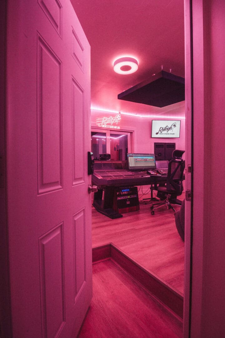 A room with pink lighting and a desk