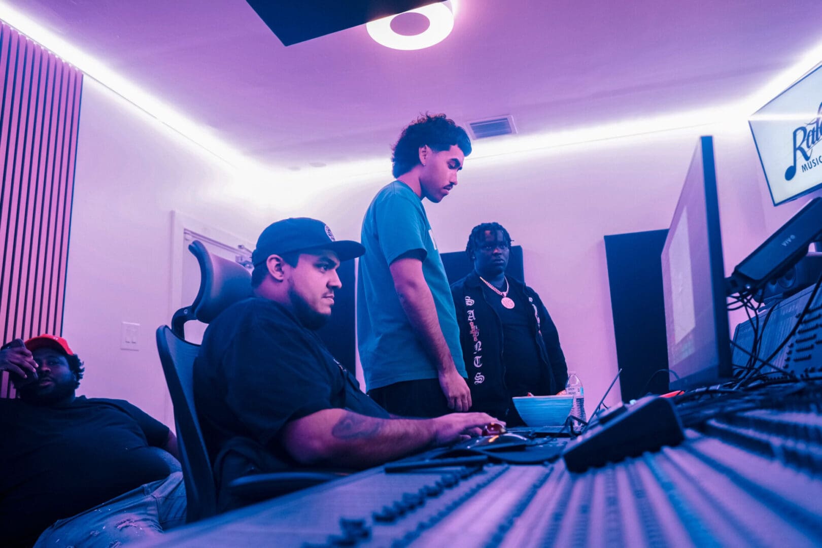 A group of people sitting around a computer.