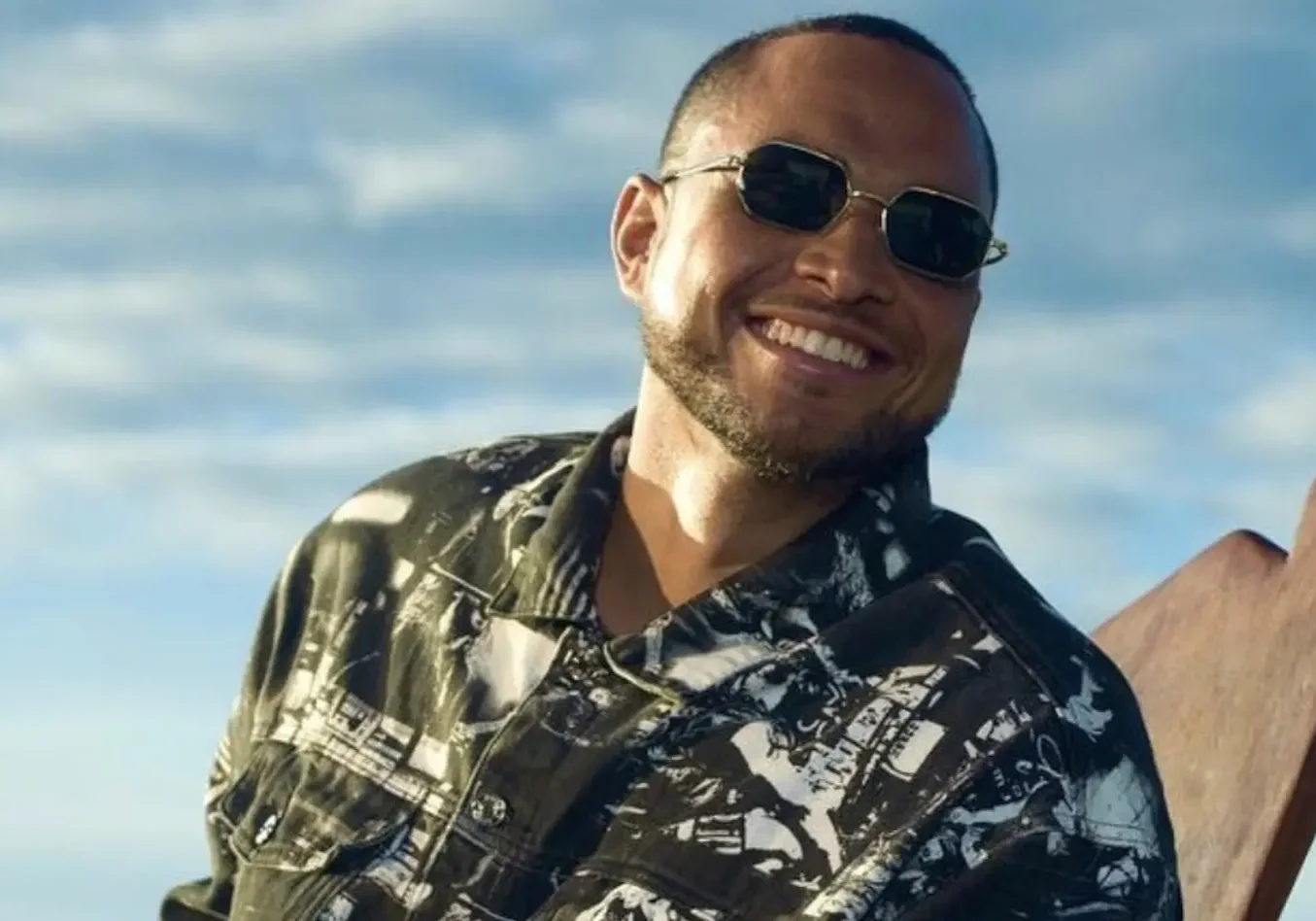 A man wearing sunglasses and smiling for the camera.