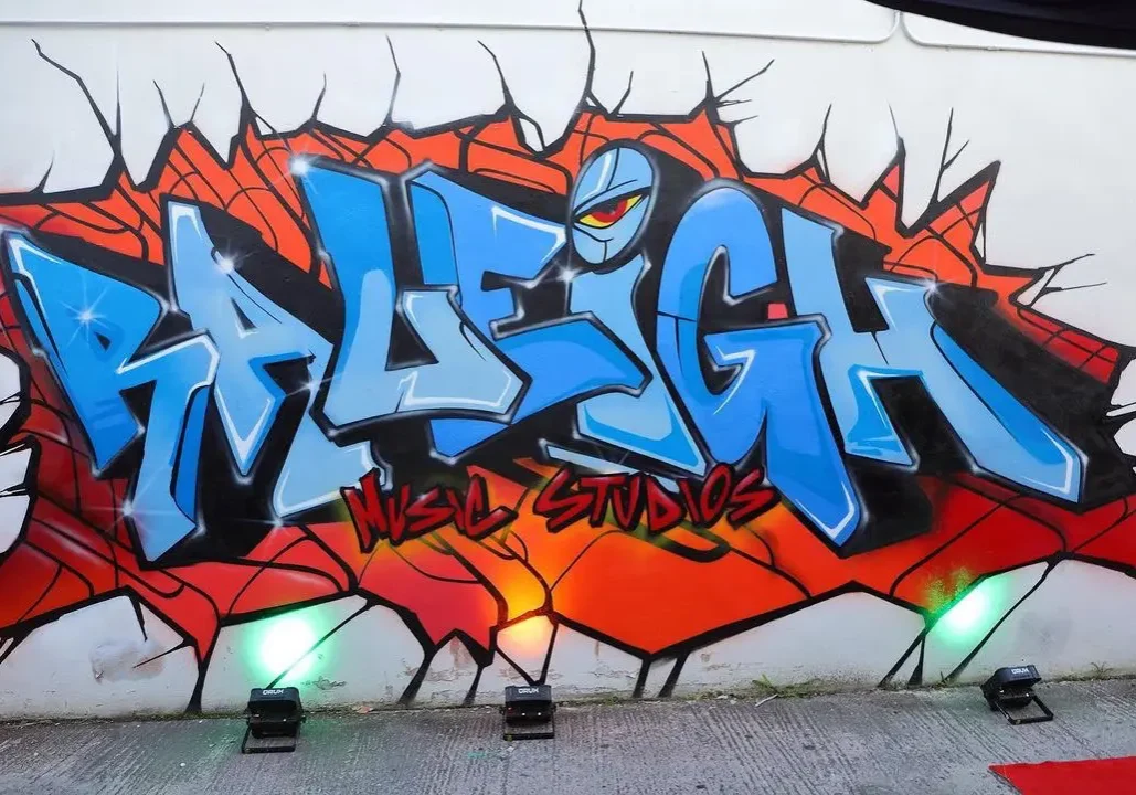 A wall with graffiti on it and the word " raleigh ".